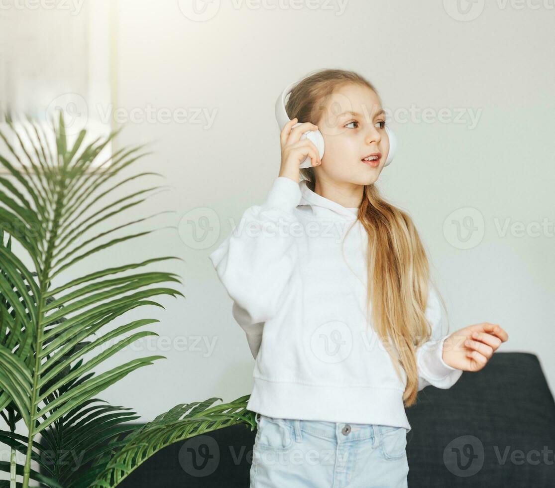 Cute little girl listening to music in headphones photo