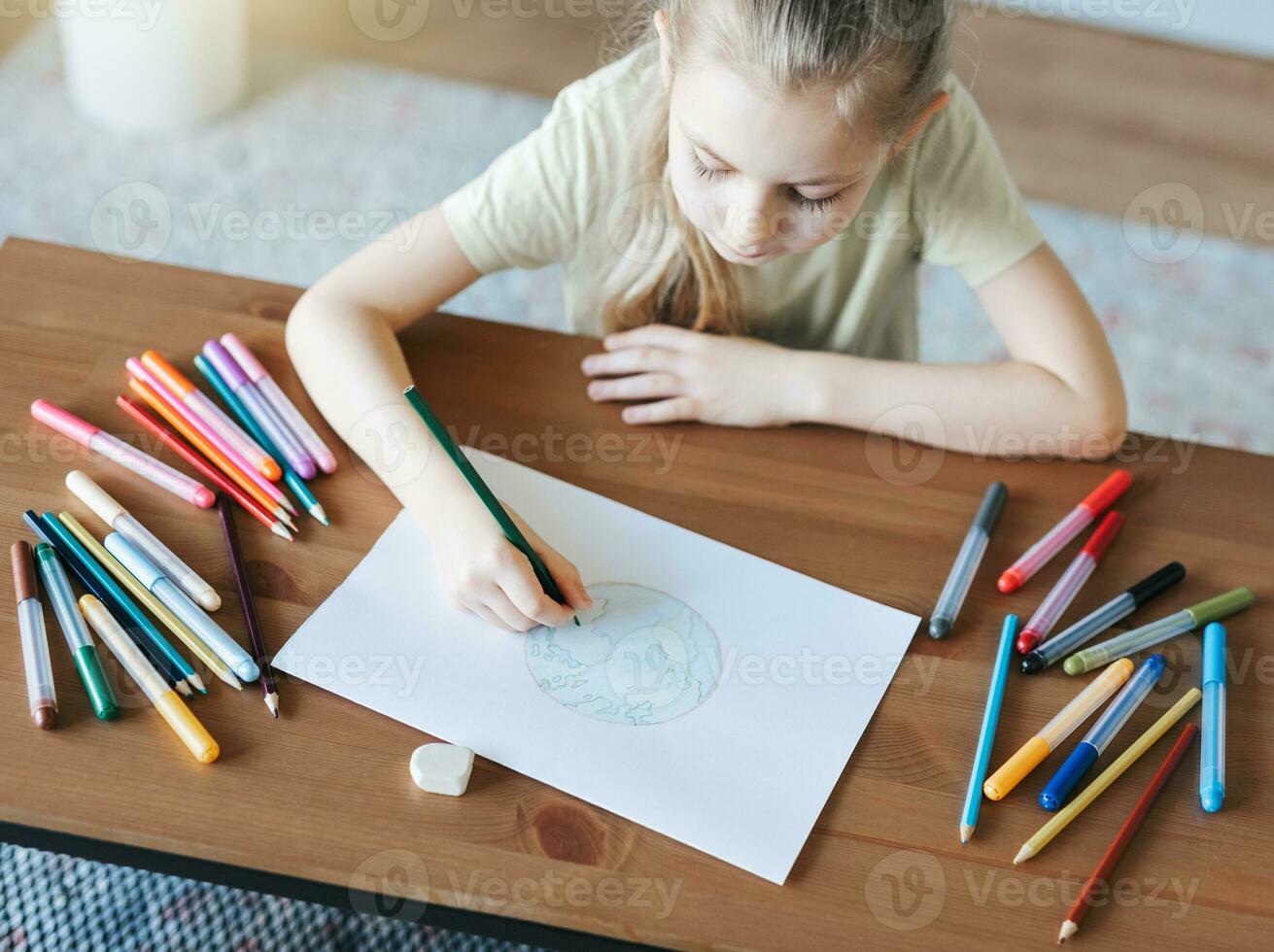 Child girl drawing with colorful pencils photo