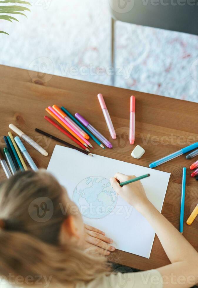 Child girl drawing with colorful pencils photo