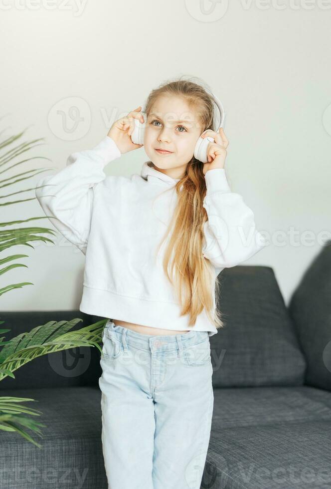 Cute little girl listening to music in headphones photo