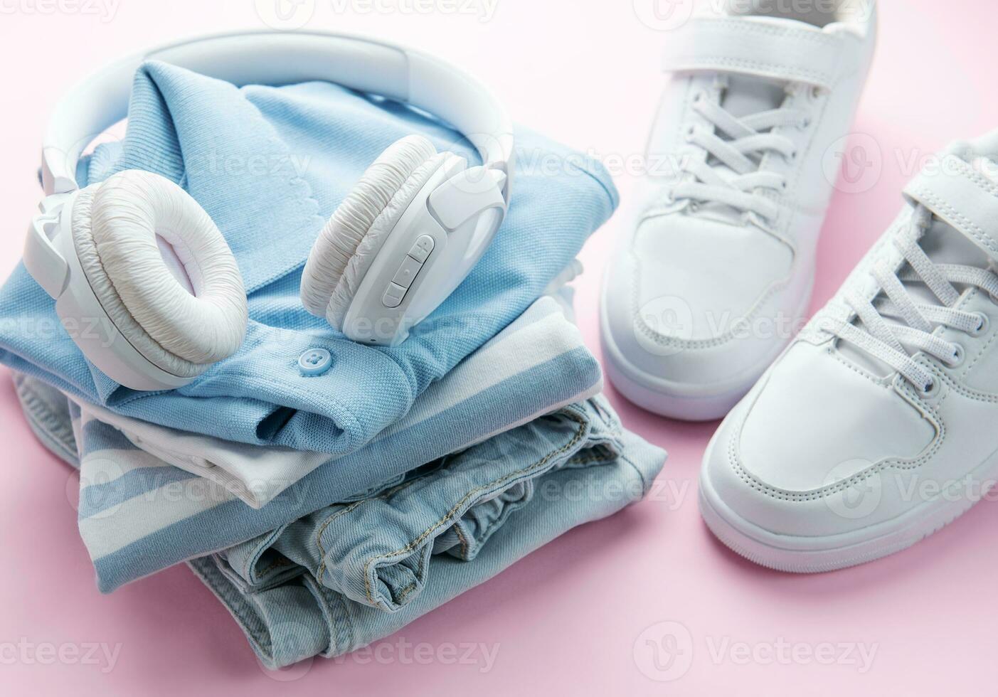 Child's t-shirt, shoes and headphones on pink backgrund photo