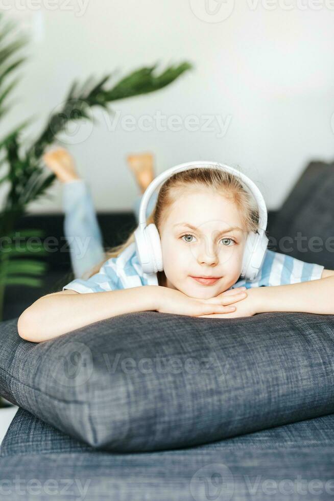 Cute little girl listening to music in headphones photo