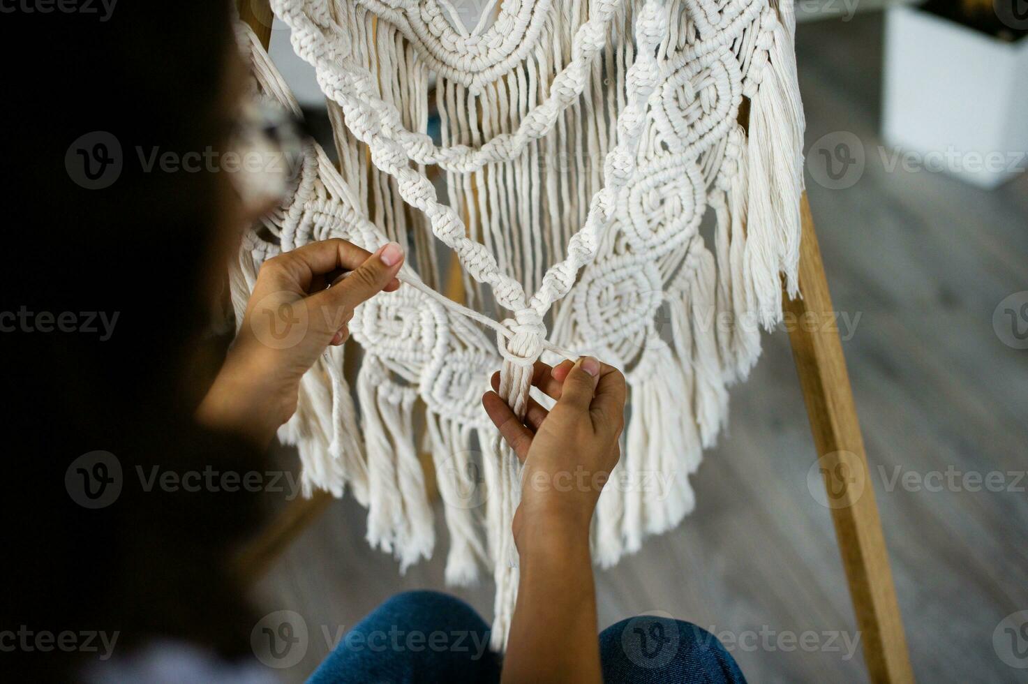 The production of boho-style panels is made of cotton threads of natural color in the macrame photo