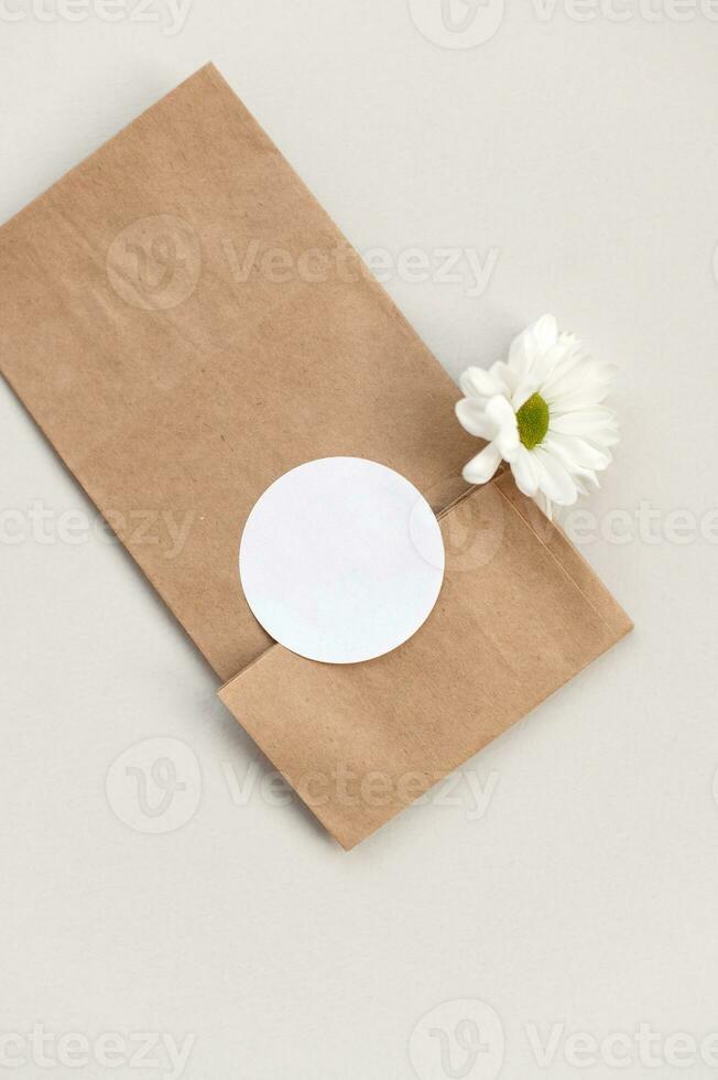 Round blank sticker model, round tag model on kraft paper gift bag, daisy flower photo