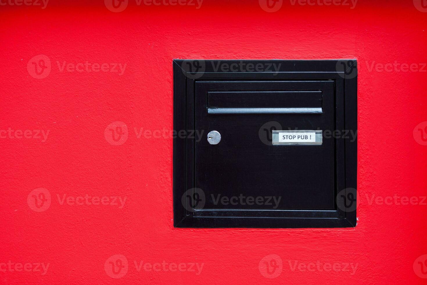 Black mailbox incrusted in a red wall photo