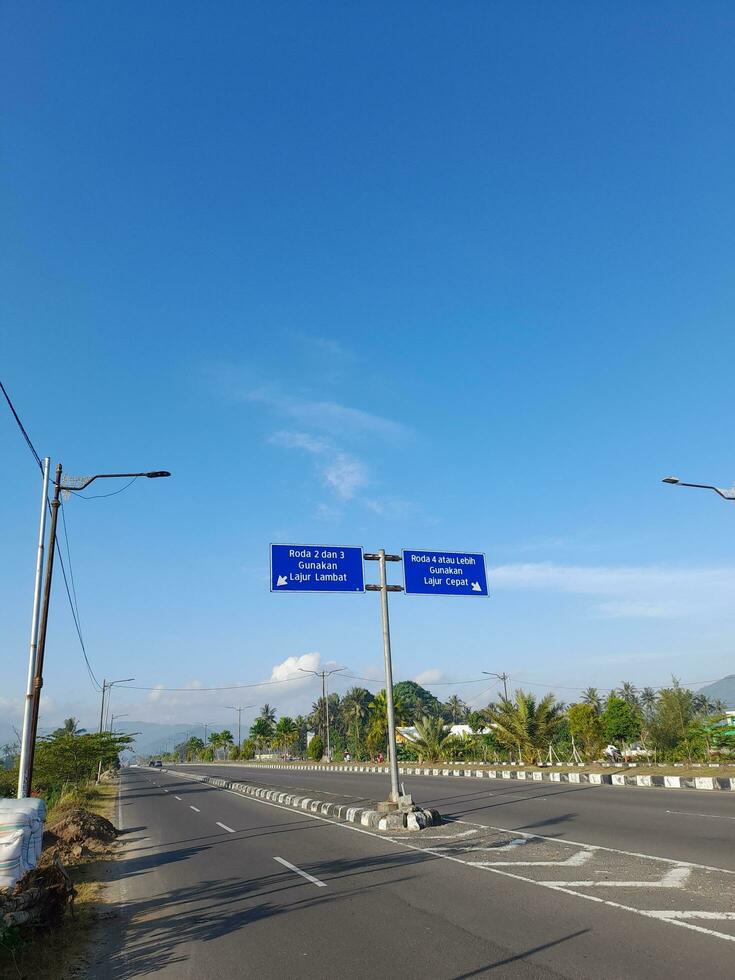 Lombok Island, Indonesia.20 May 2023. Slow and fast lane dividing sign on road in Lombok island, Indonesia photo