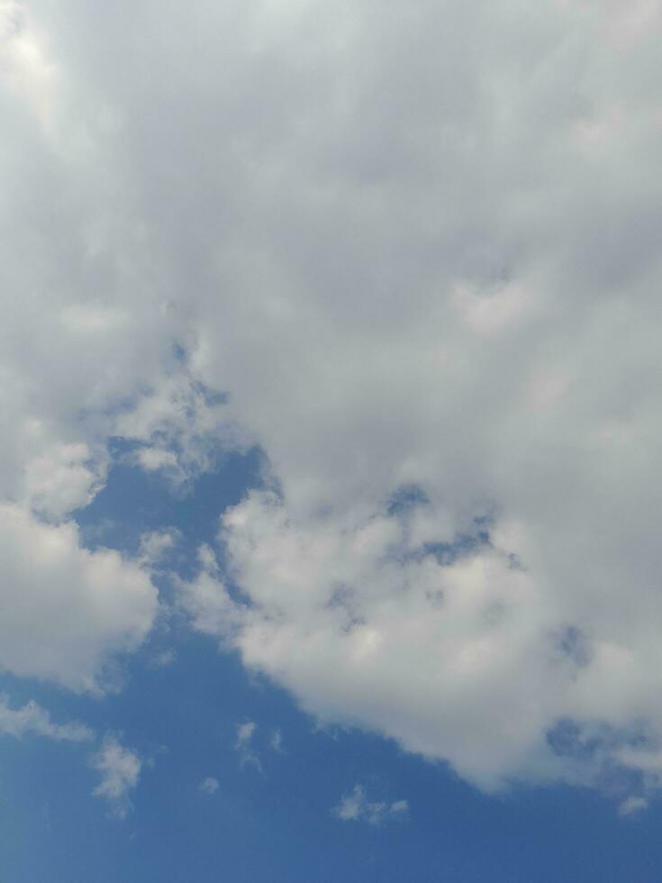 White clouds in the blue sky. Beautiful bright blue background. Light cloudy, good weather. Curly clouds on a sunny day. photo
