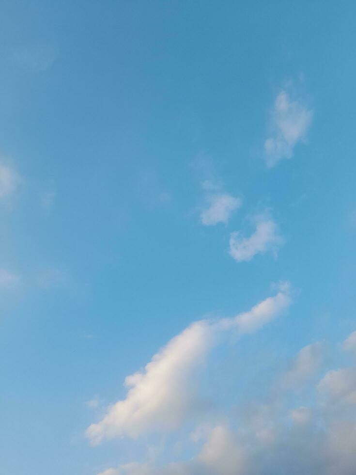 White clouds in the blue sky. Beautiful bright blue background. Light cloudy, good weather. Curly clouds on a sunny day. photo