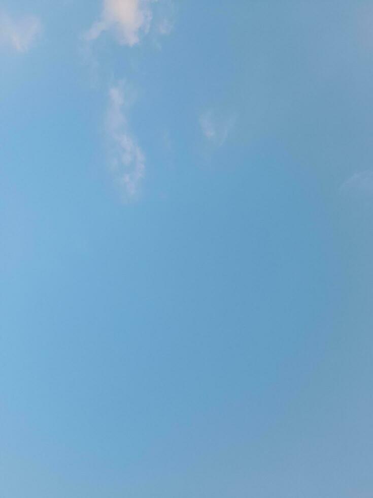 White clouds in the blue sky. Beautiful bright blue background. Light cloudy, good weather. Curly clouds on a sunny day. photo