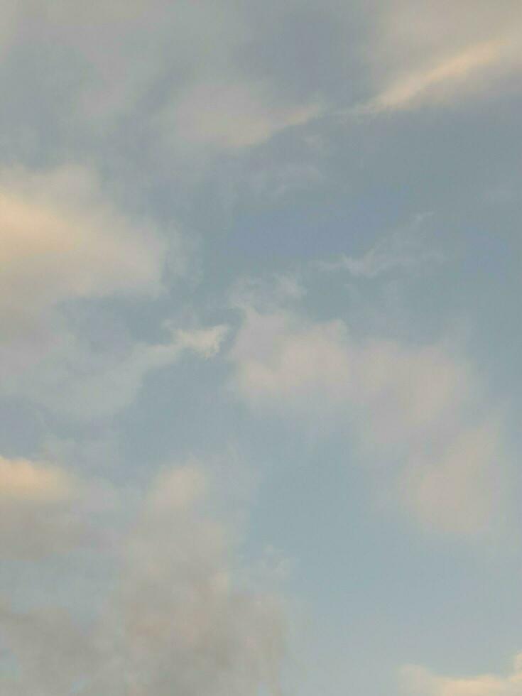 White clouds in the blue sky. Beautiful bright blue background. Light cloudy, good weather. Curly clouds on a sunny day. photo