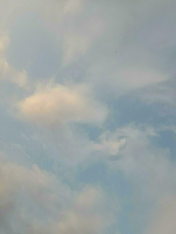 White clouds in the blue sky. Beautiful bright blue background. Light cloudy, good weather. Curly clouds on a sunny day. photo