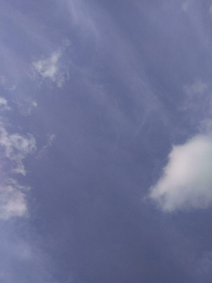 White clouds in the blue sky. Beautiful bright blue background. Light cloudy, good weather. Curly clouds on a sunny day. photo