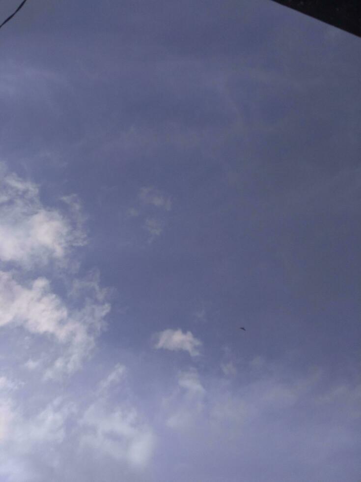 White clouds in the blue sky. Beautiful bright blue background. Light cloudy, good weather. Curly clouds on a sunny day. photo