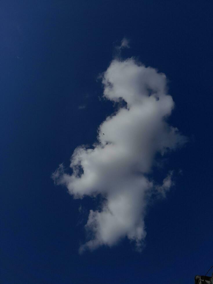 White clouds in the blue sky. Beautiful bright blue background. Light cloudy, good weather. Curly clouds on a sunny day. photo