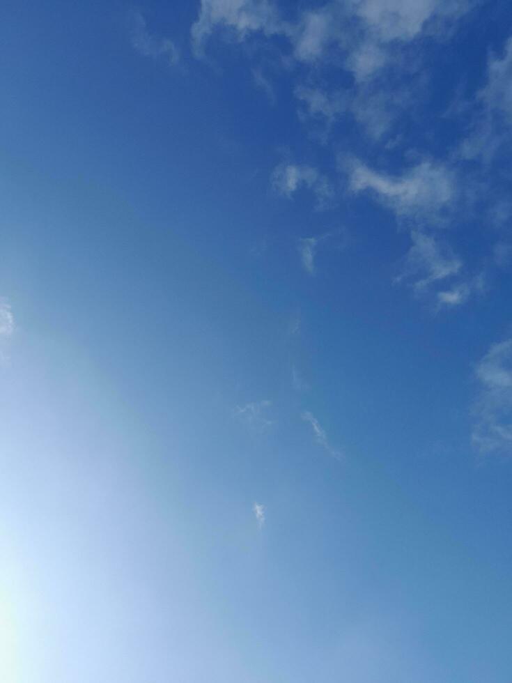 White clouds in the blue sky. Beautiful bright blue background. Light cloudy, good weather. Curly clouds on a sunny day. photo