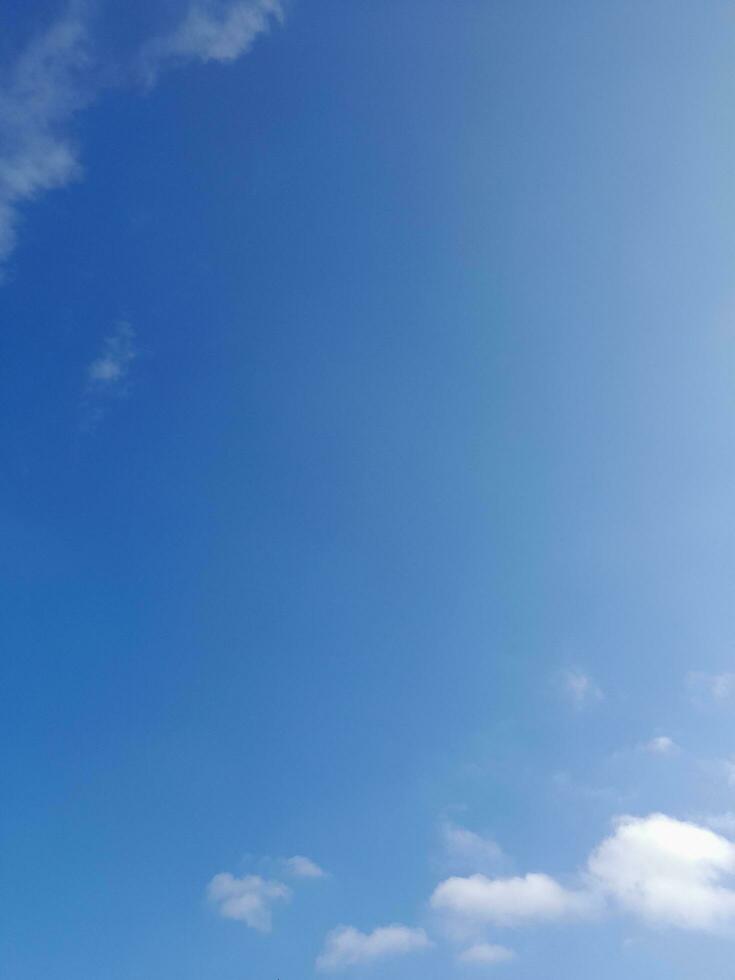 White clouds in the blue sky. Beautiful bright blue background. Light cloudy, good weather. Curly clouds on a sunny day. photo