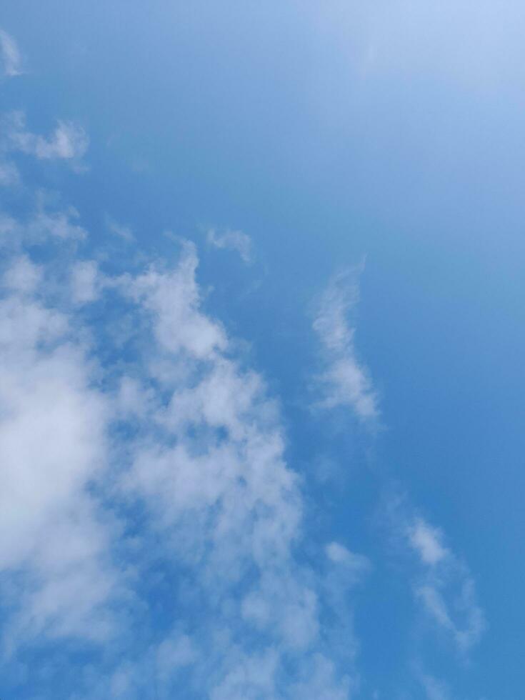 White clouds in the blue sky. Beautiful bright blue background. Light cloudy, good weather. Curly clouds on a sunny day. photo
