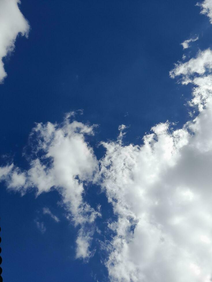 White clouds in the blue sky. Beautiful bright blue background. Light cloudy, good weather. Curly clouds on a sunny day. photo