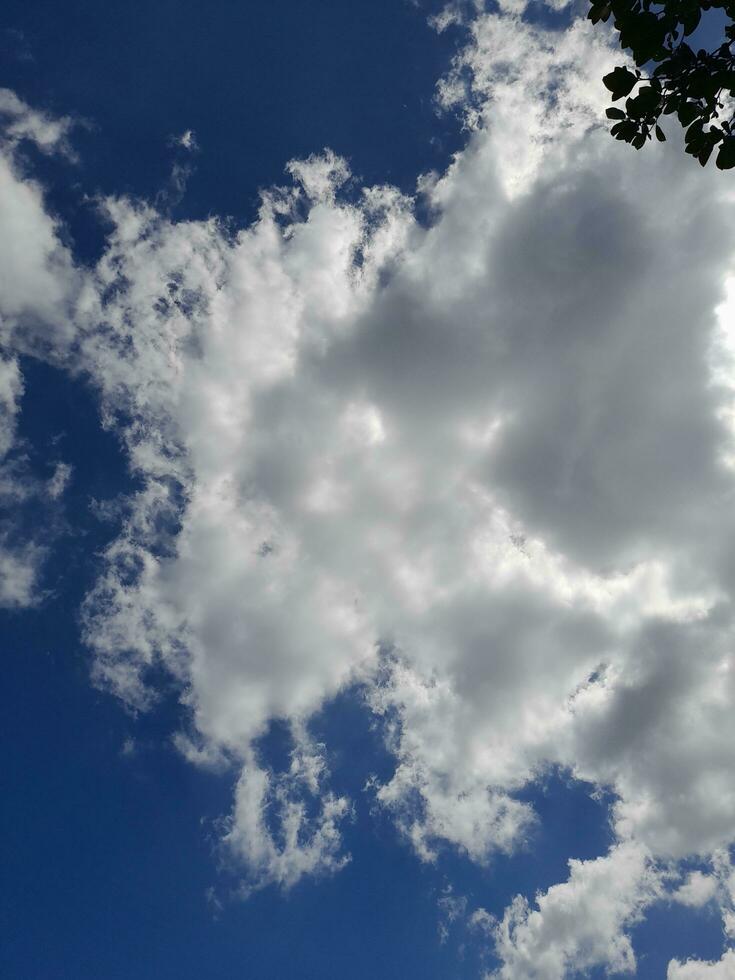 White clouds in the blue sky. Beautiful bright blue background. Light cloudy, good weather. Curly clouds on a sunny day. photo