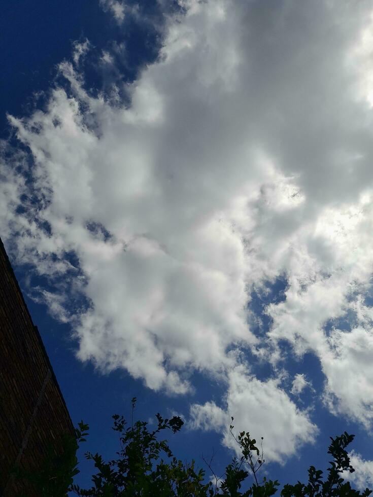 White clouds in the blue sky. Beautiful bright blue background. Light cloudy, good weather. Curly clouds on a sunny day. photo