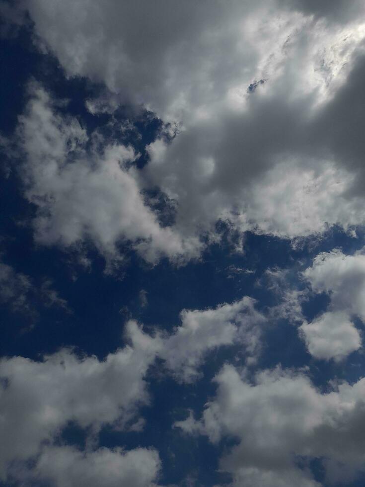 White clouds in the blue sky. Beautiful bright blue background. Light cloudy, good weather. Curly clouds on a sunny day. photo