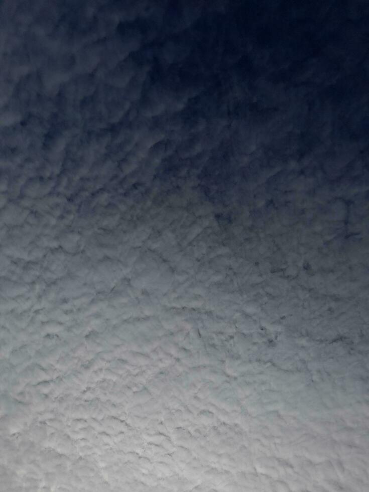 White clouds in the blue sky. Beautiful bright blue background. Light cloudy, good weather. Curly clouds on a sunny day. photo