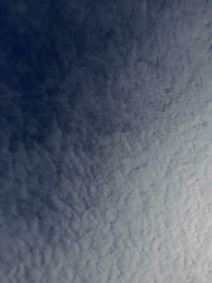 White clouds in the blue sky. Beautiful bright blue background. Light cloudy, good weather. Curly clouds on a sunny day. photo