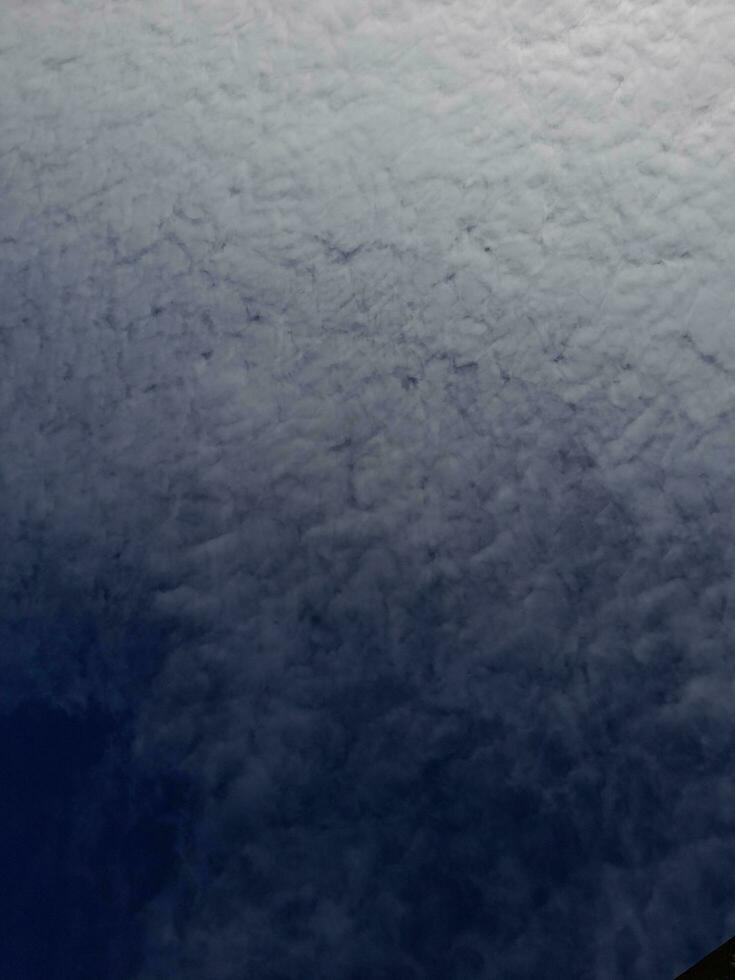 White clouds in the blue sky. Beautiful bright blue background. Light cloudy, good weather. Curly clouds on a sunny day. photo