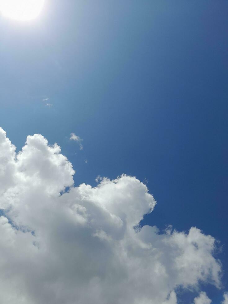 White clouds in the blue sky. Beautiful bright blue background. Light cloudy, good weather. Curly clouds on a sunny day. photo
