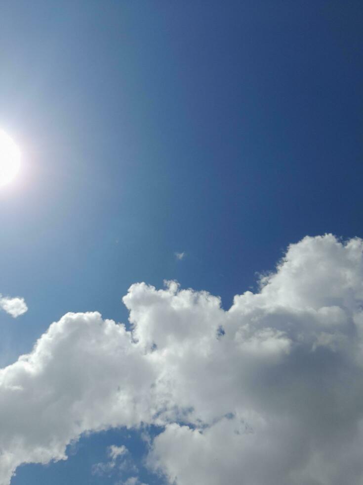 White clouds in the blue sky. Beautiful bright blue background. Light cloudy, good weather. Curly clouds on a sunny day. photo