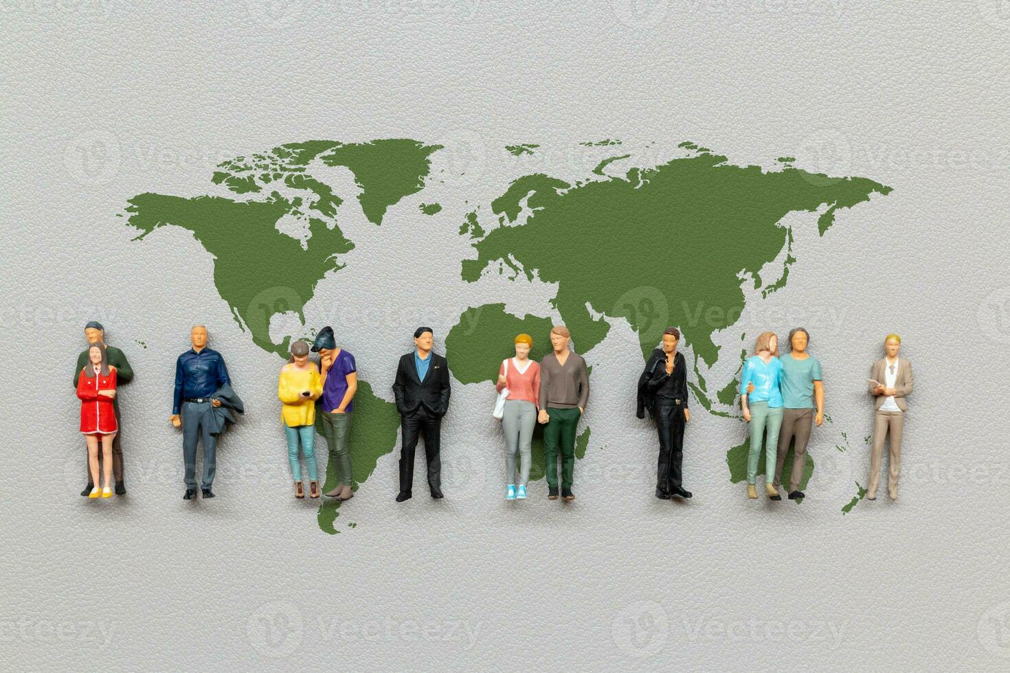 Miniature people standing on the world map with gray background photo