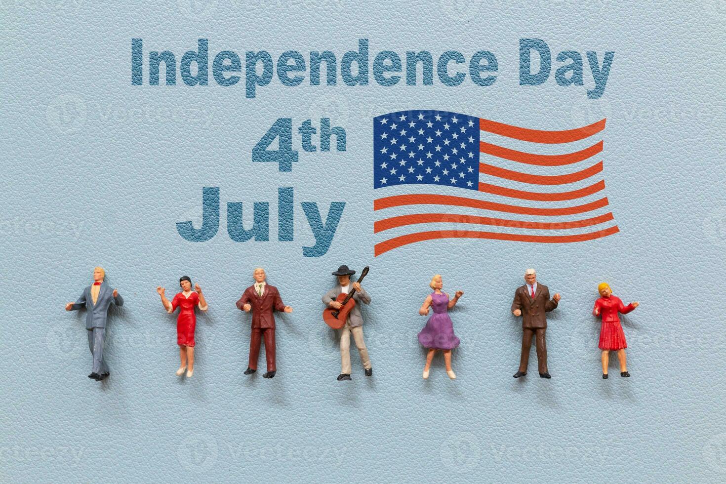 Group of people celebrating the Fourth of July with the American flag in the background. photo