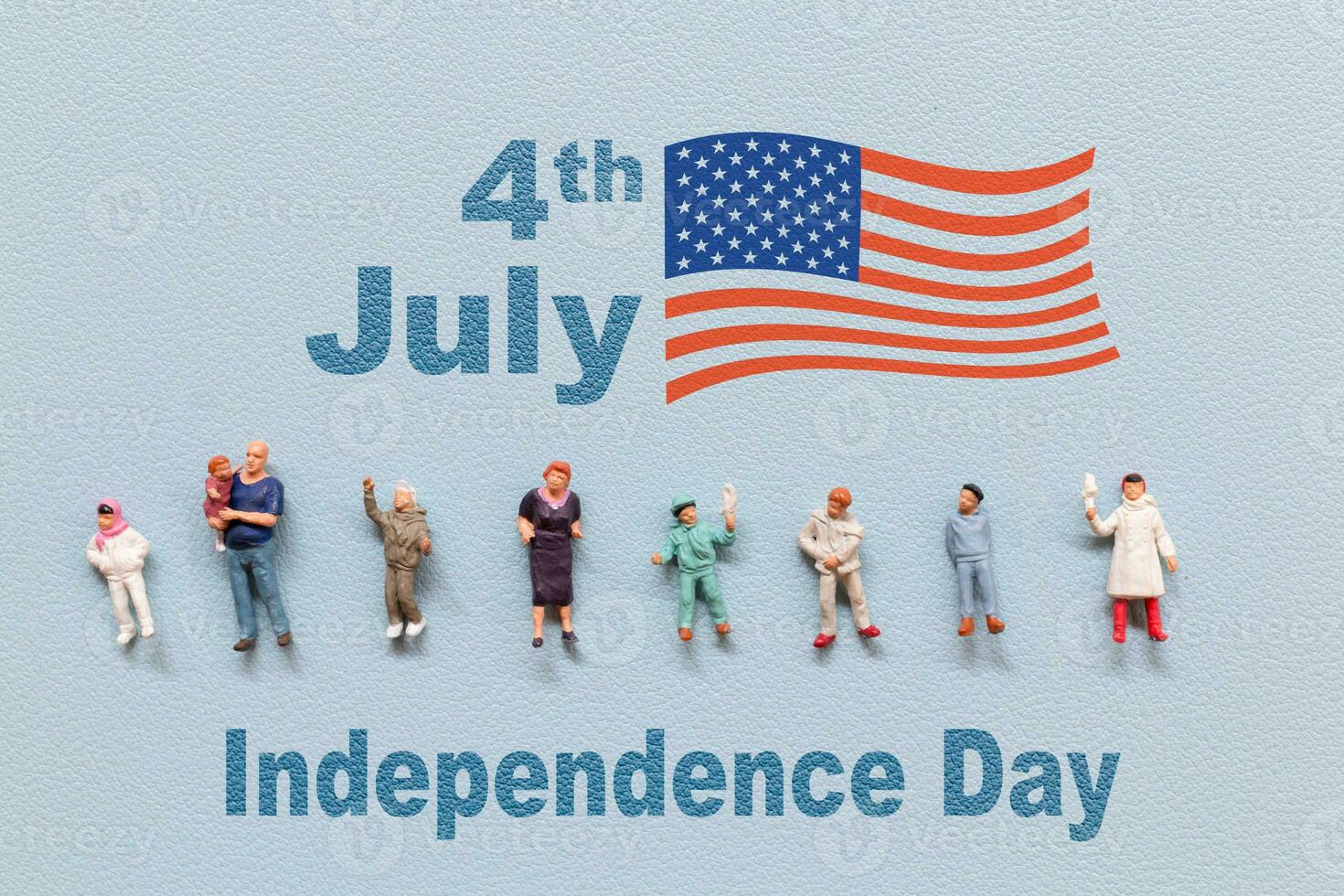 Group of people celebrating the Fourth of July with the American flag in the background. photo