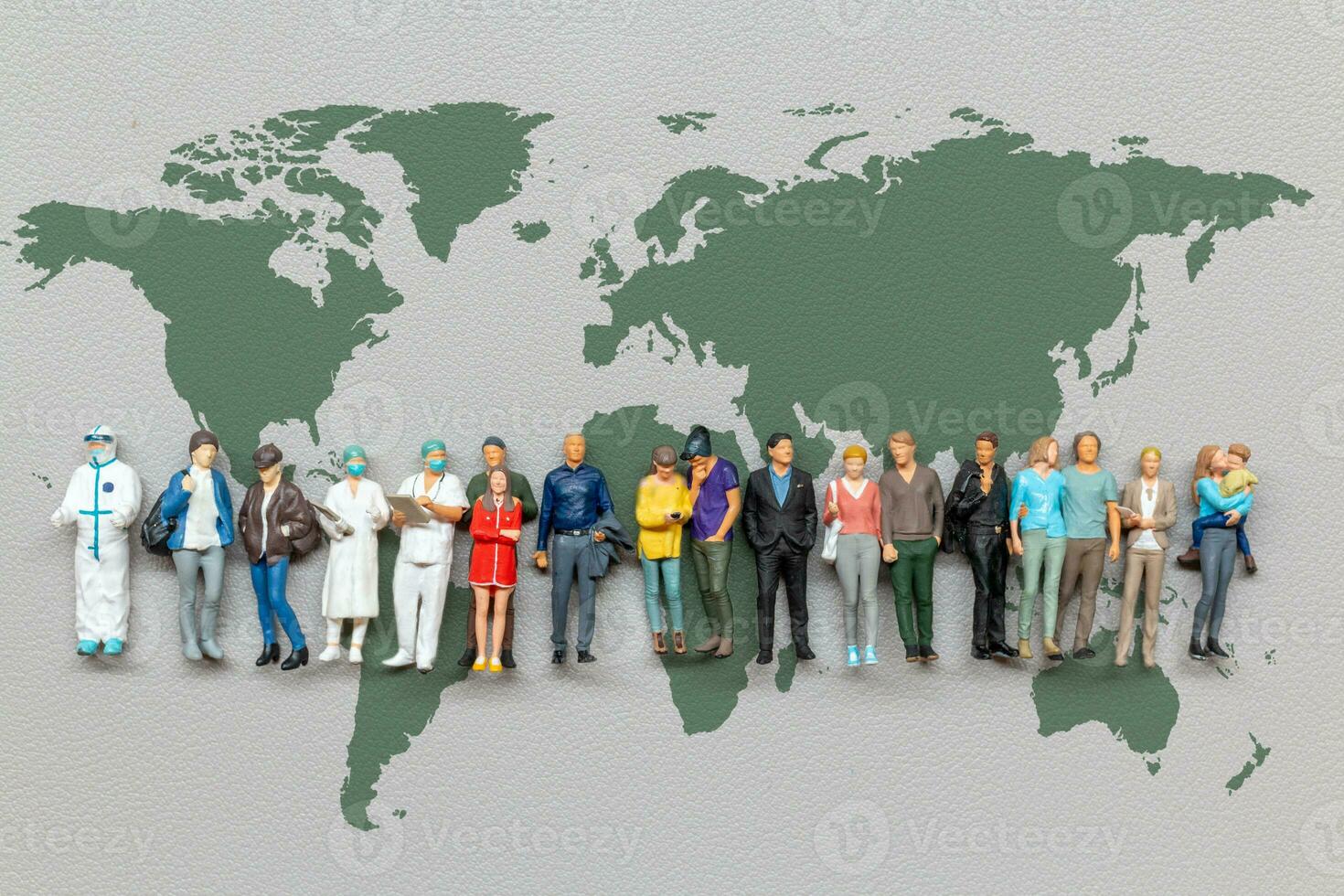 miniatura personas en pie en el mundo mapa con gris antecedentes foto