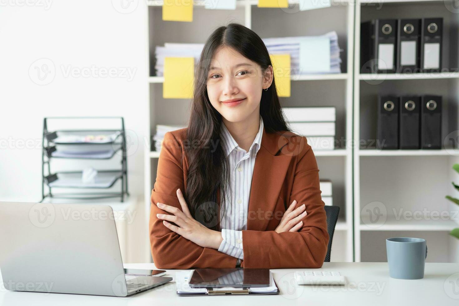 asiático mujer de negocios sonriente con confianza exitoso empresario elegante profesional empresa ejecutivo vistiendo un traje en pie en el oficina con brazos cruzado. foto