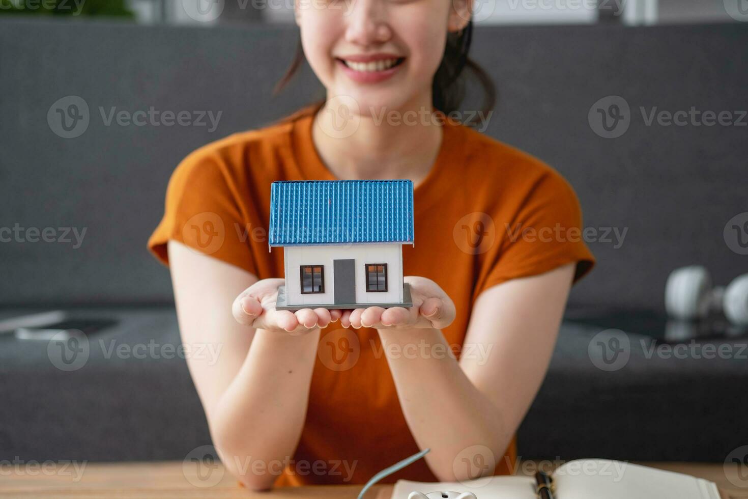 Young Asian woman calculating the cost of selling a house and analyzing the return on real estate investments. Real estate accounting concepts and tax system. photo