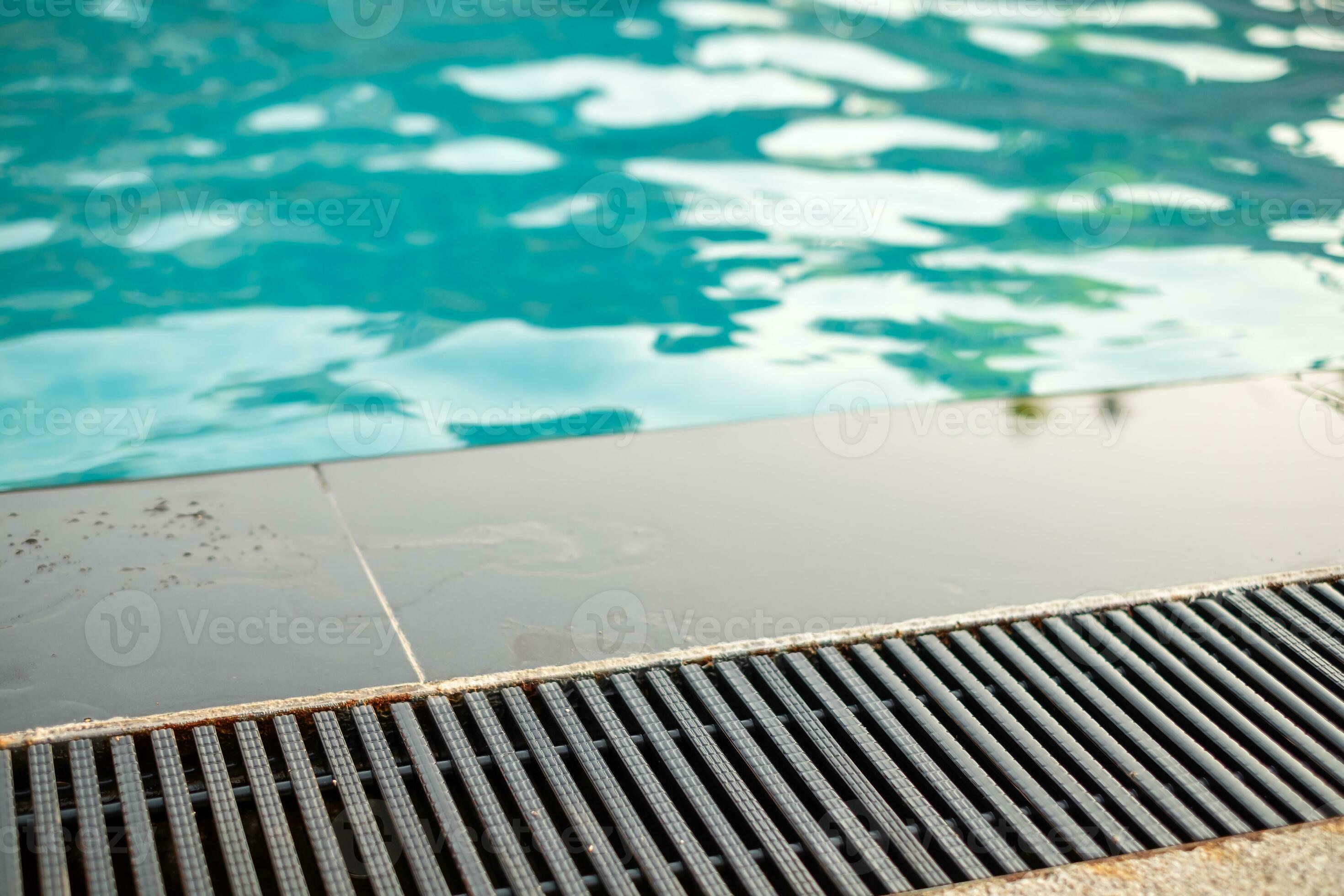 Black gutter is installed beside swimming pool, drainage system