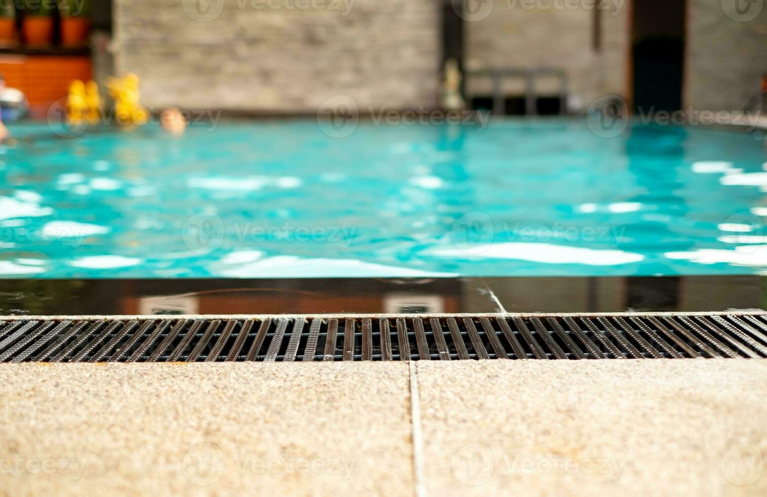 Black gutter is installed beside swimming pool, drainage system, overflow gutter, private pool, pool edge. photo