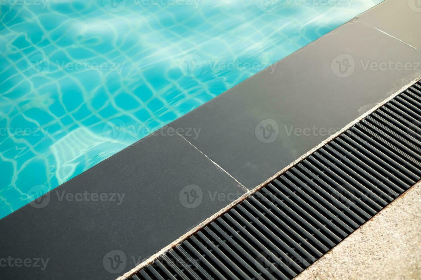 Black gutter is installed beside swimming pool, drainage system