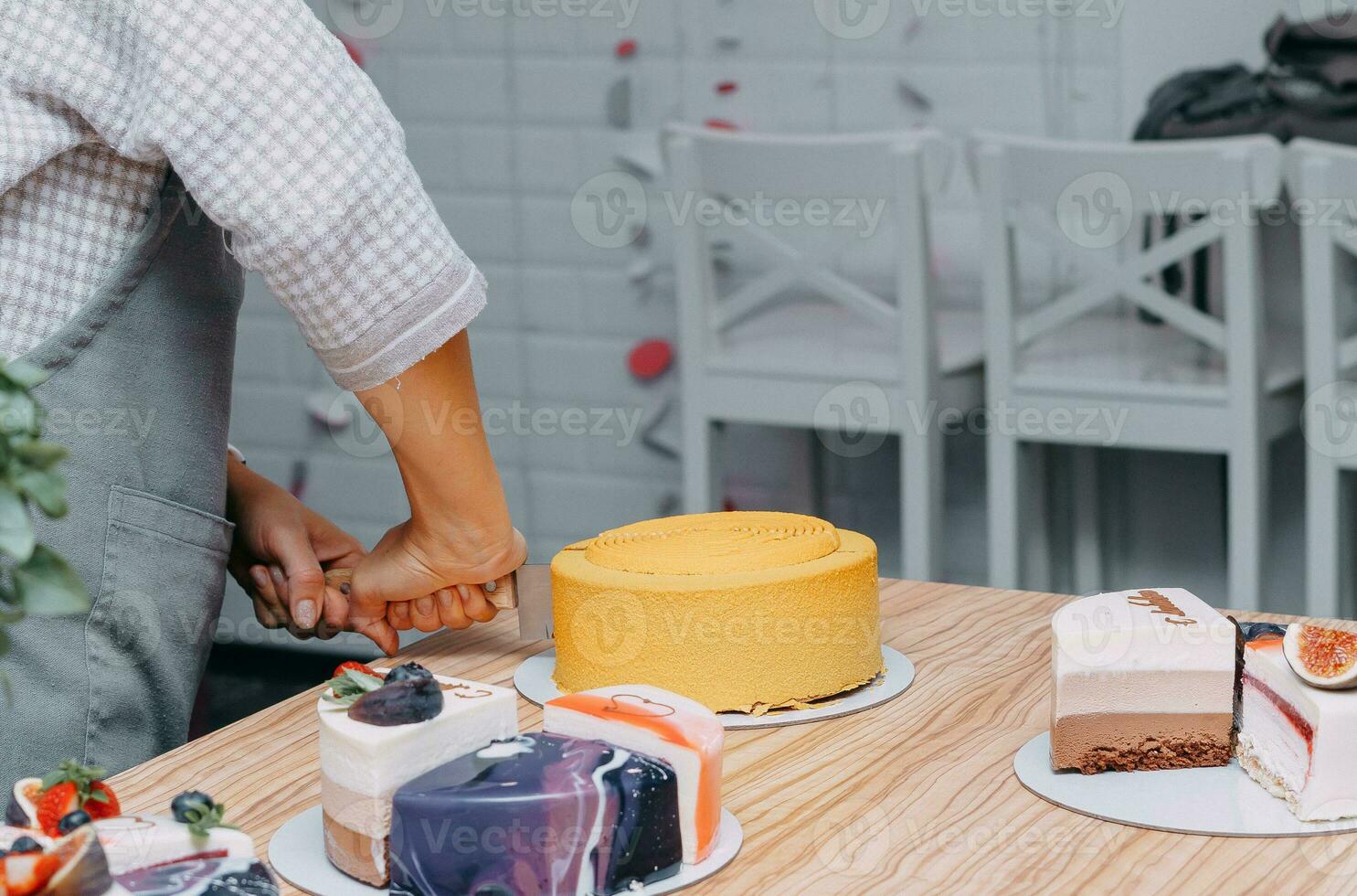 Cutting a chocolate mousse cake on the table. Preparation of mousse cakes at a culinary master class. Cooking at home, homemade food photo