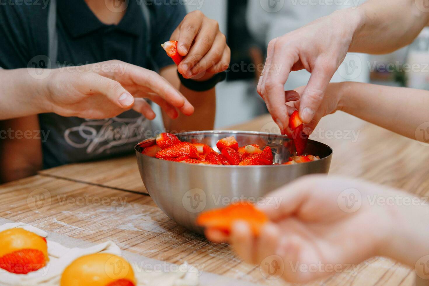 Preparing a dessert at a cooking master class. Baskets with peaches and strawberries, home cooking. Close-up, selective focus. Pastries, pies with peaches from puff pastry. photo