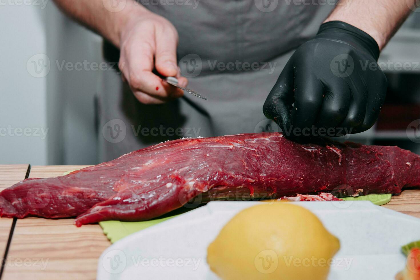 Raw beef meat for steak preparation. Raw beef sliced, preparation of meat for cooking steak at the culinary master class. Raw meat on a black plate. photo