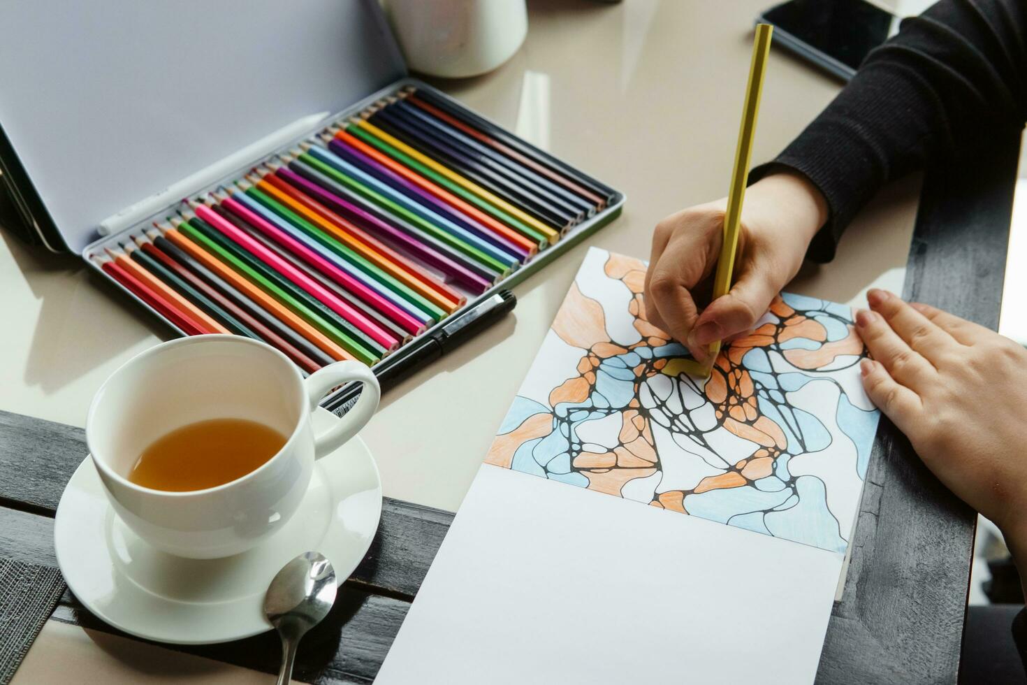 TVER, RUSSIA - FEBRUARY 11, 2023 a young woman draws neurography at a table at a psychological session, a neurographic resunok with a pencil to remove oranicheniy, art therapy photo