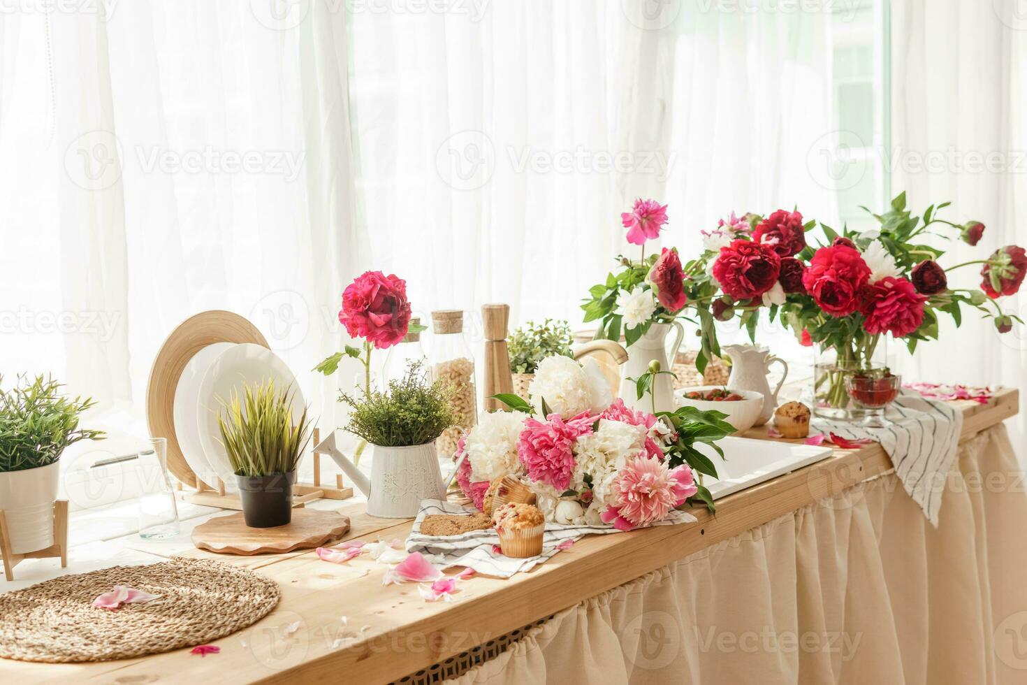 The kitchen countertop is decorated with peonies. The interior is decorated with spring flowers. photo