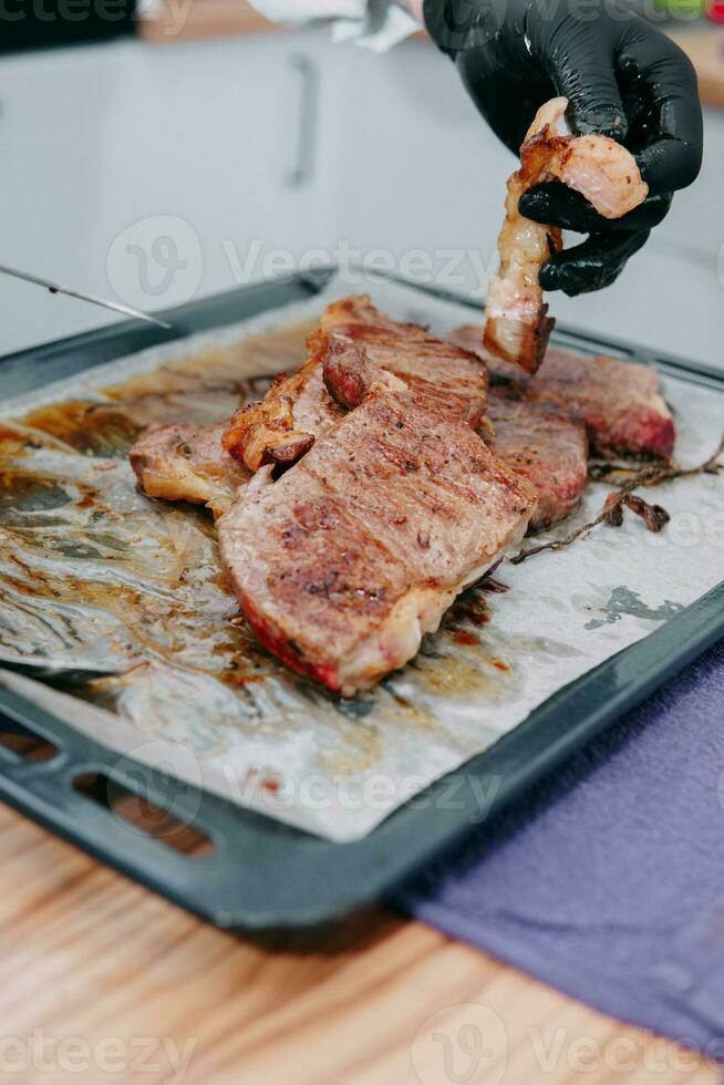carne de vaca filete con verduras en un negro lámina. filete con albahaca cocido en el culinario Maestro clase foto
