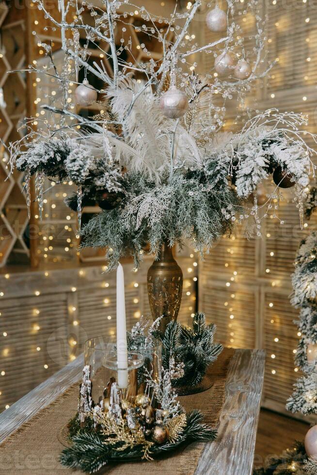 A candle in a candlestick decorated in a Christmas theme. A decor concept for home decoration for the New Year holidays, table decoration for Christmas. photo