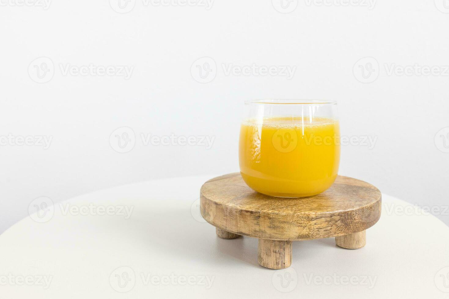 Fresh squeezed orange juice in glass on table on white background. Healthy beverage for breakfast photo