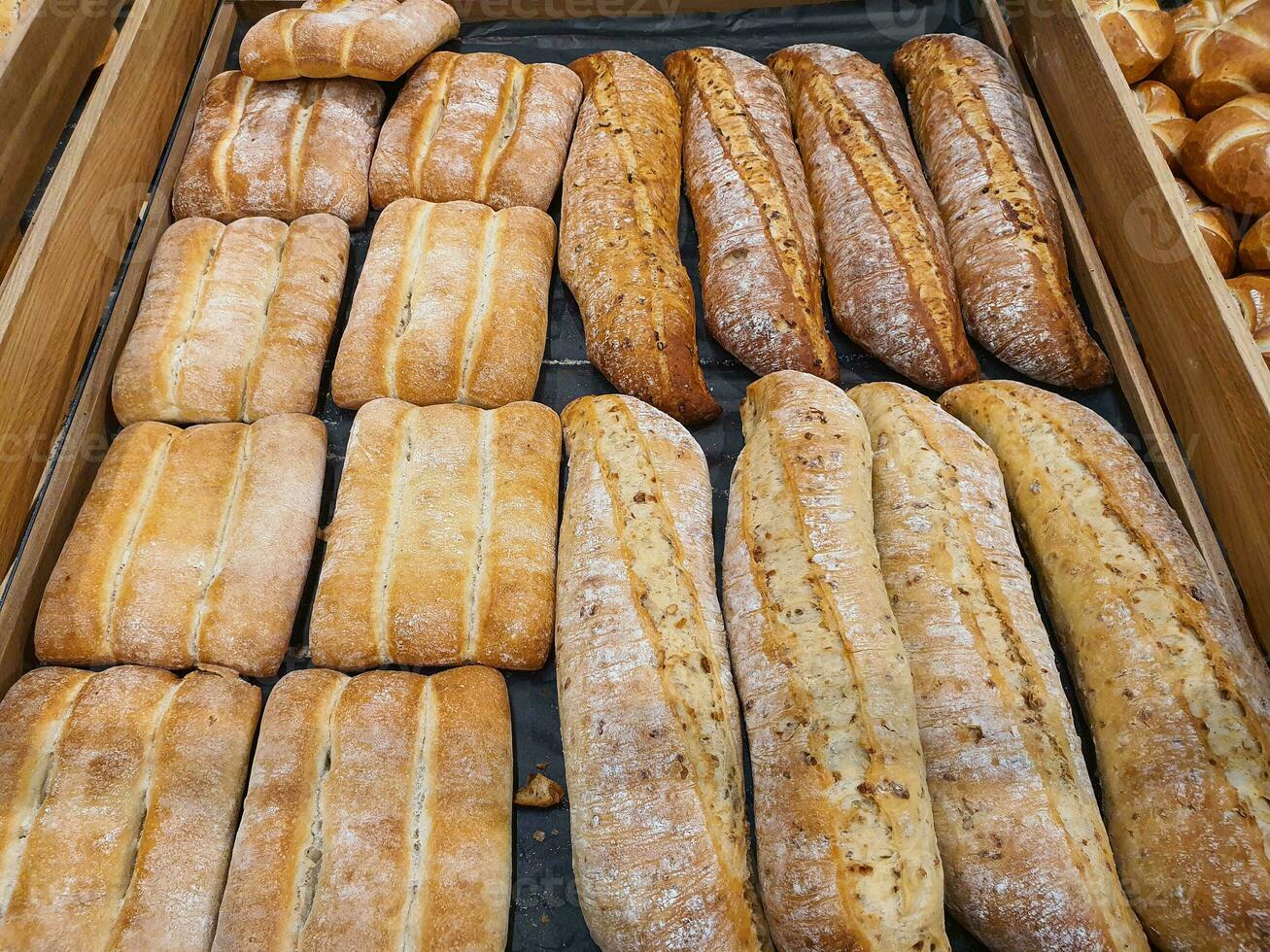 Different types of baguettes and buns in a bakery photo
