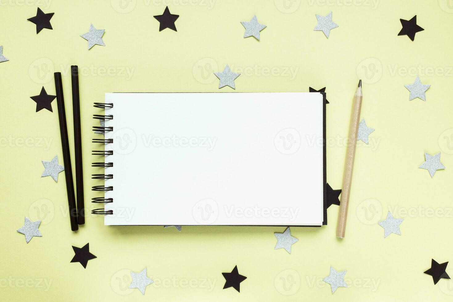 Open sketchbook or notebook and charcoal pencils photo
