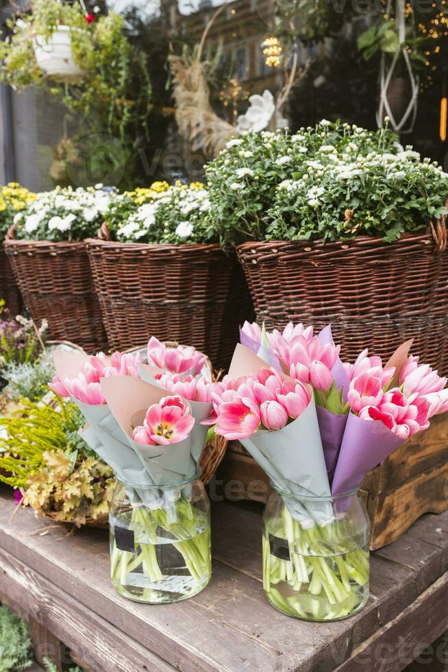 Tulips, heather, chrysanthemum and hanging flowers and wreaths at the flower shop photo